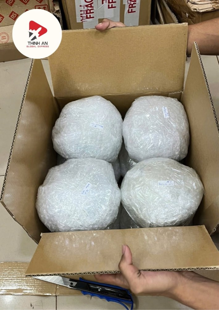 Bốn món hàng dễ vỡ được bọc xốp hơi riêng từng món, xếp sát nhau trong thùng carton